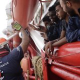 Un volontaire de l'Ocean Viking salue un groupe de migrants (archives).